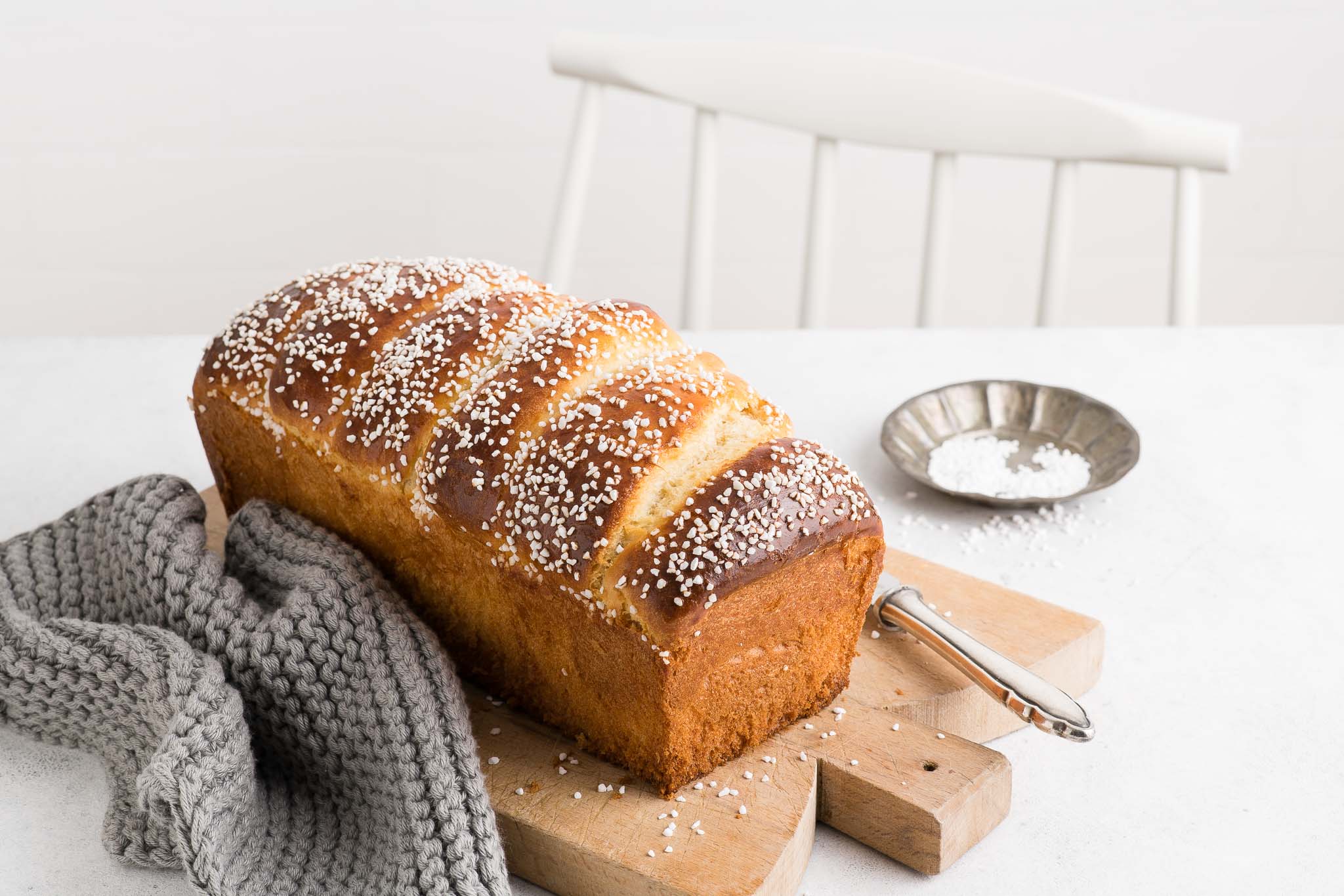 french brioche loaf on wooden board sprinkled with pearl sugar