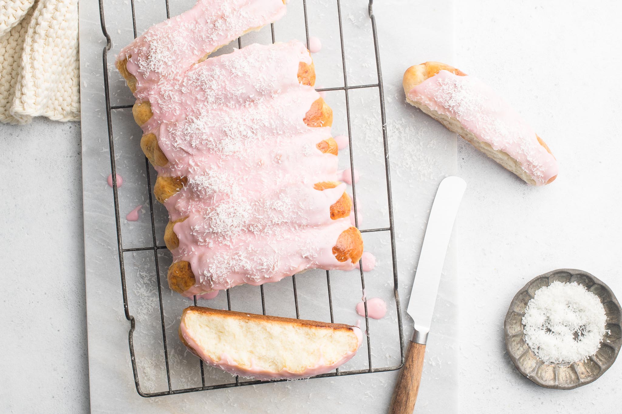 finger buns with pink icing on wire rack