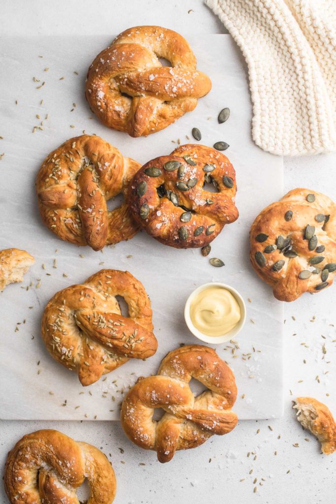 soft pretzels on marble surface sprinkled with seeds