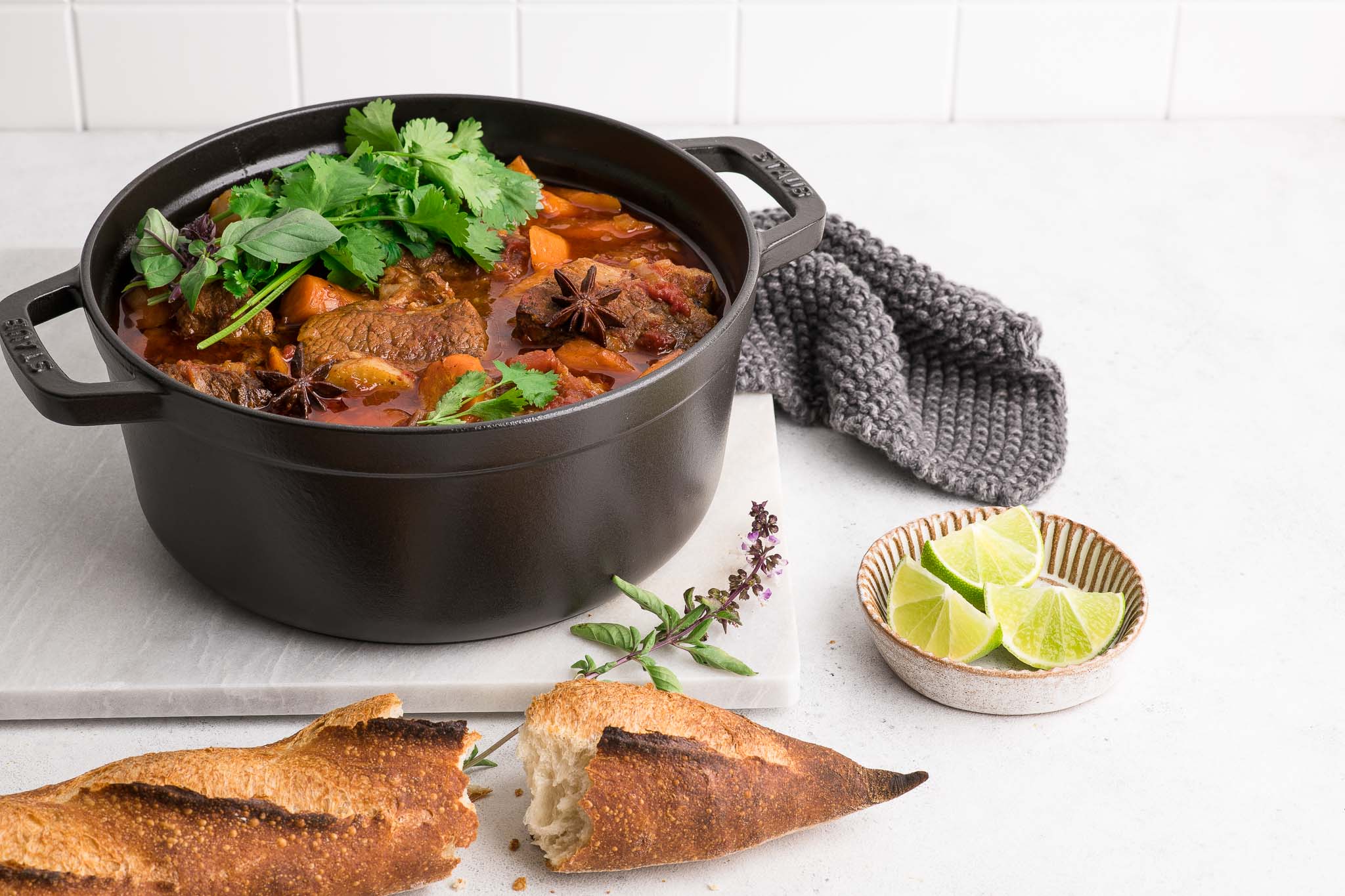 vietnamese beef stew bo kho in black pot on marble table with baguette