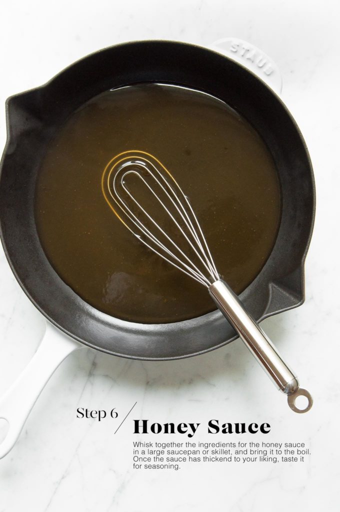 honey sauce in white skillet with whisk