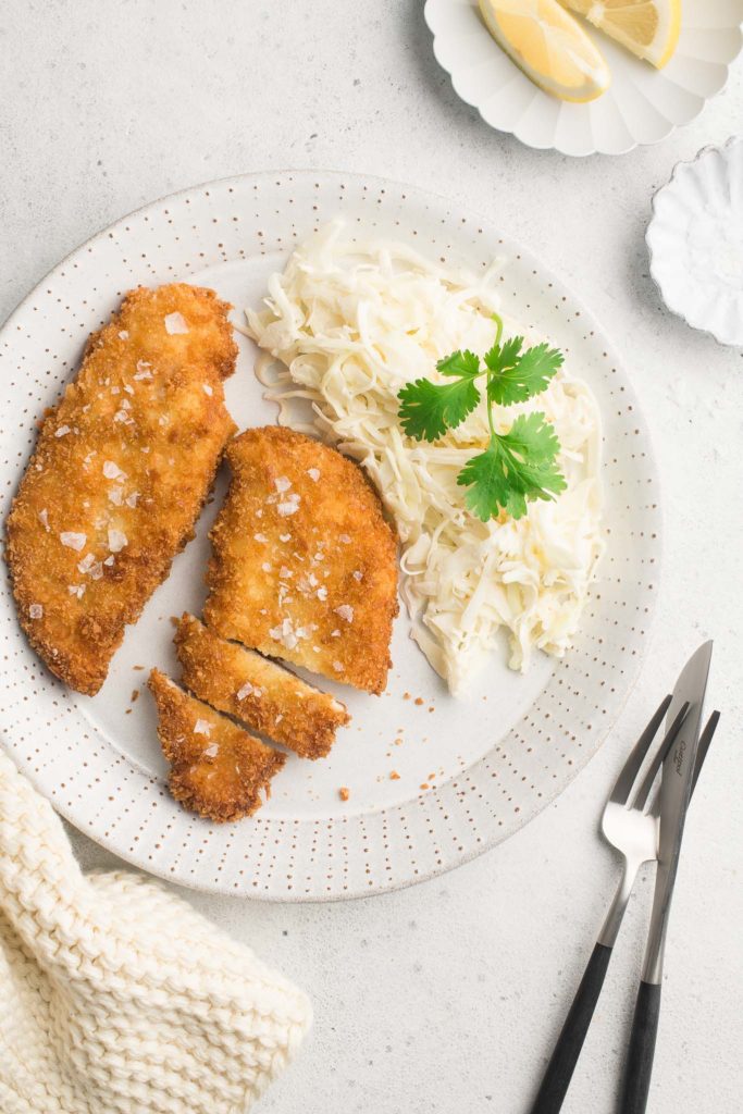 chicken schnitzel on white plate with coleslaw