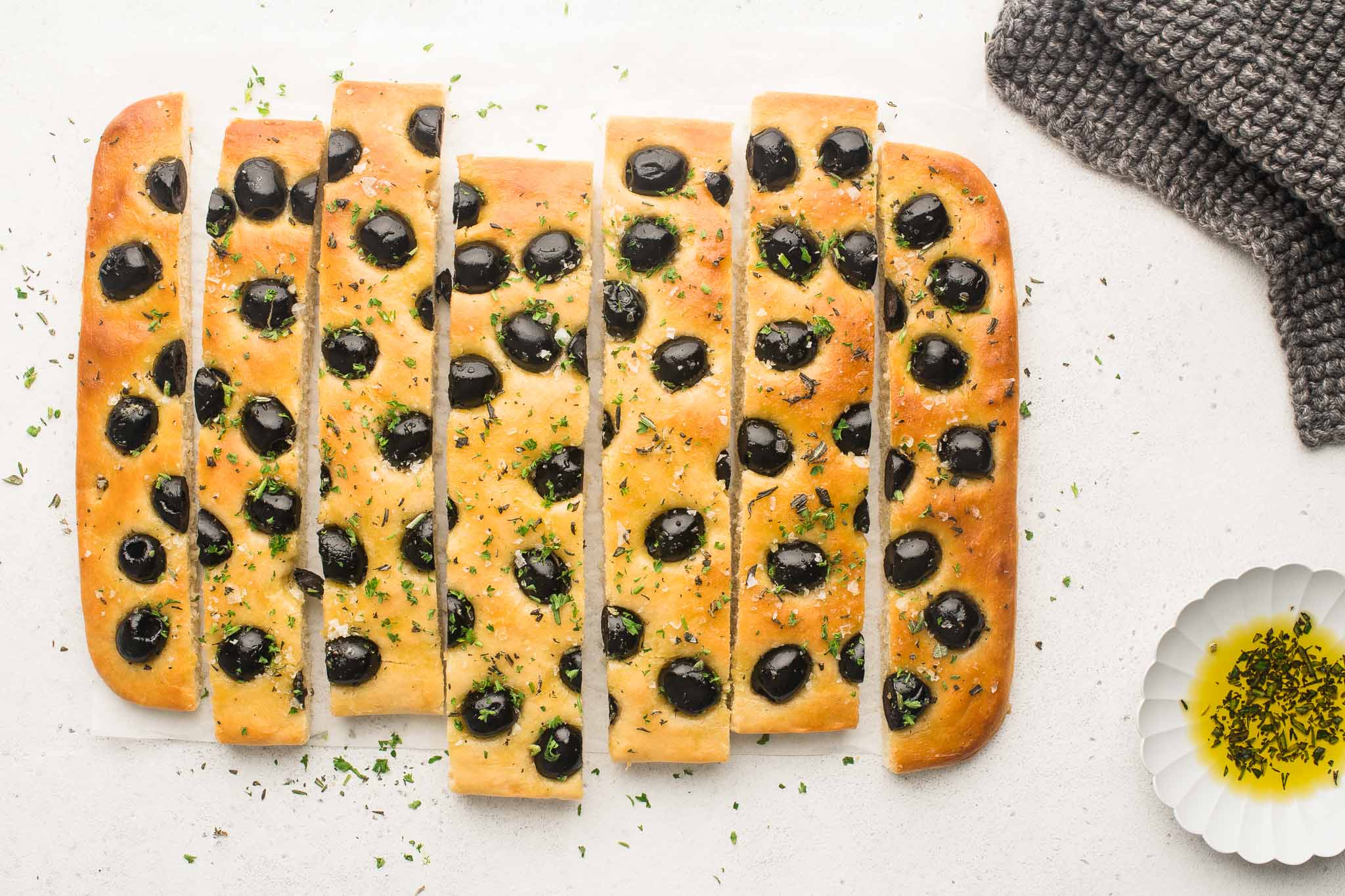 focaccia with herbs and olives sliced into lengths