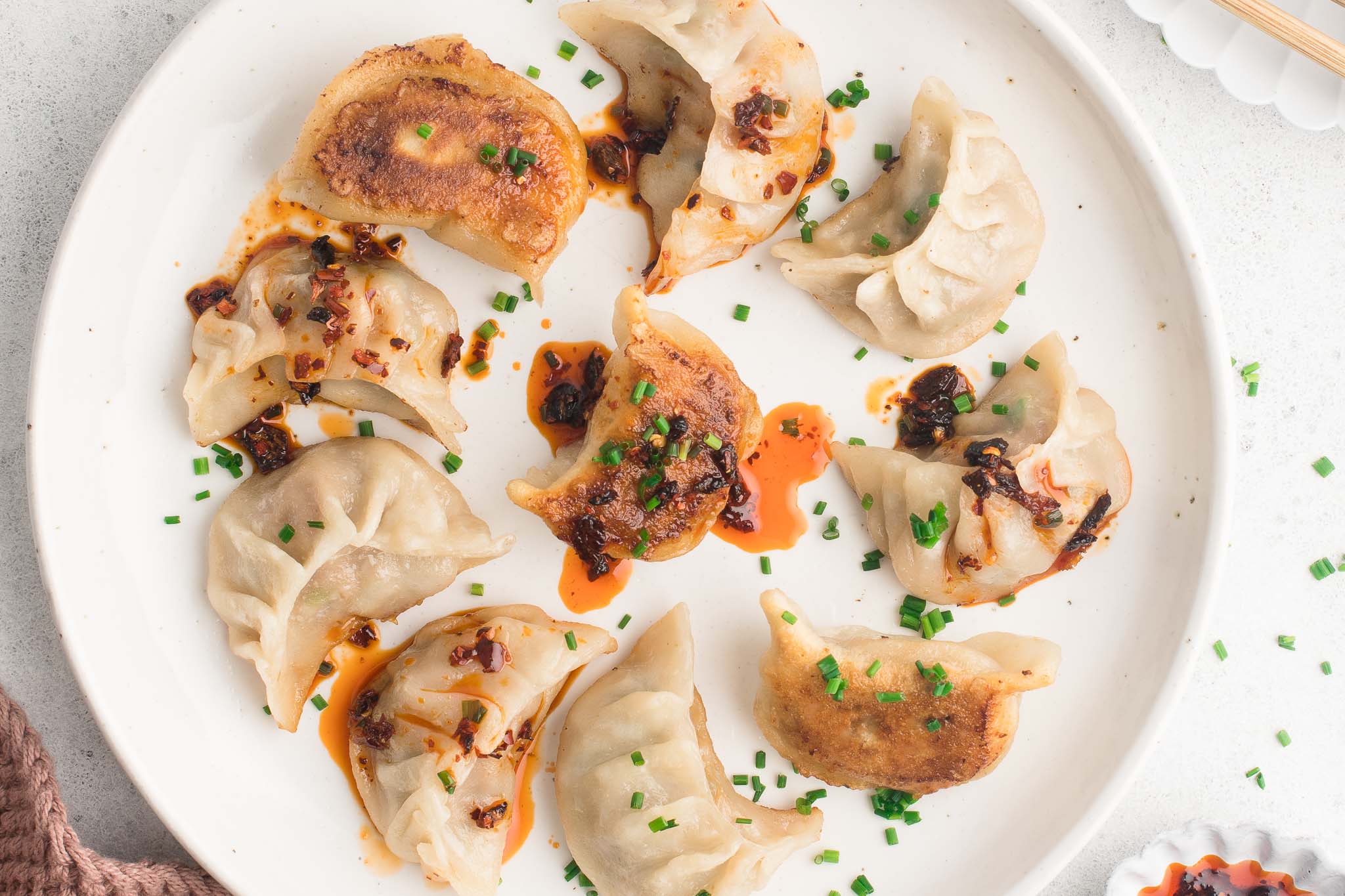 pork potstickers on white plate with spicy chili crisp
