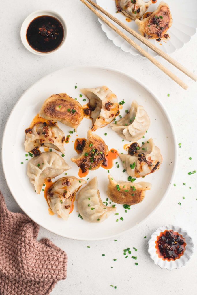 pork potstickers with chilli oil on white plate