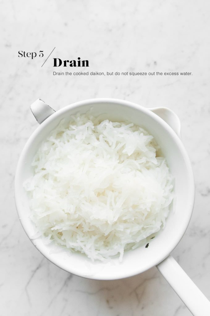 drained and cooked daikon radish in white colander