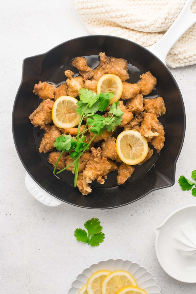 chinese lemon chicken in skillet with fresh herbs