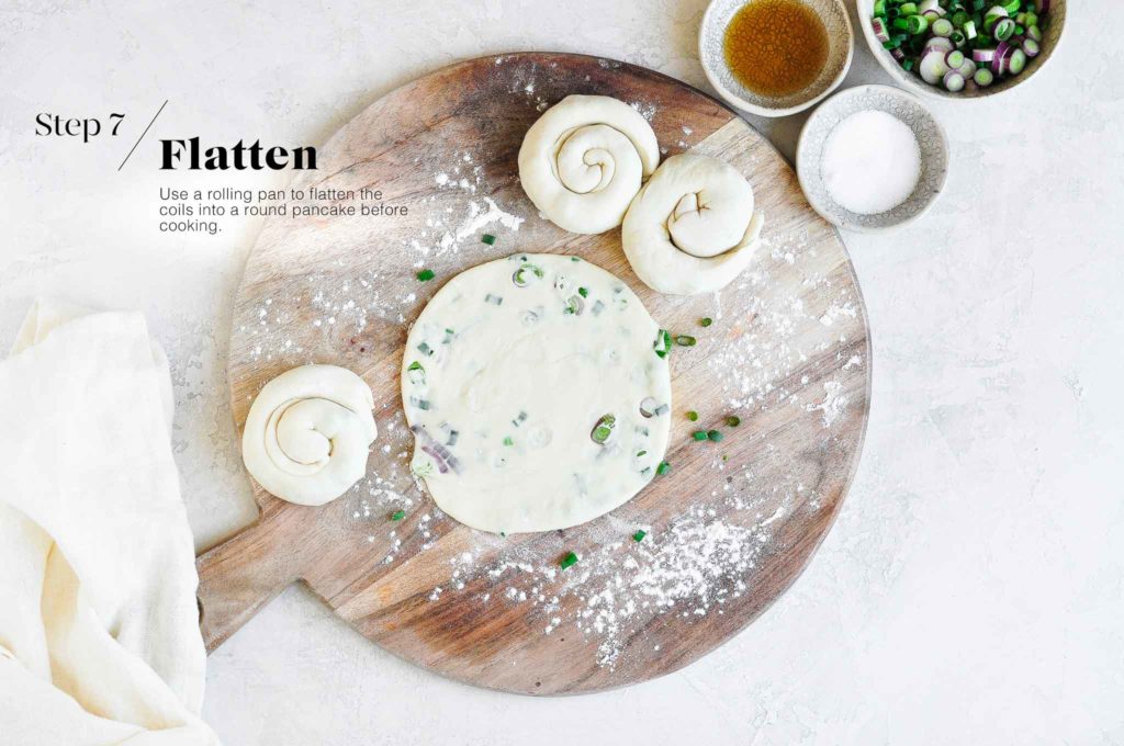 rolling out scallion pancake dough on wooden board