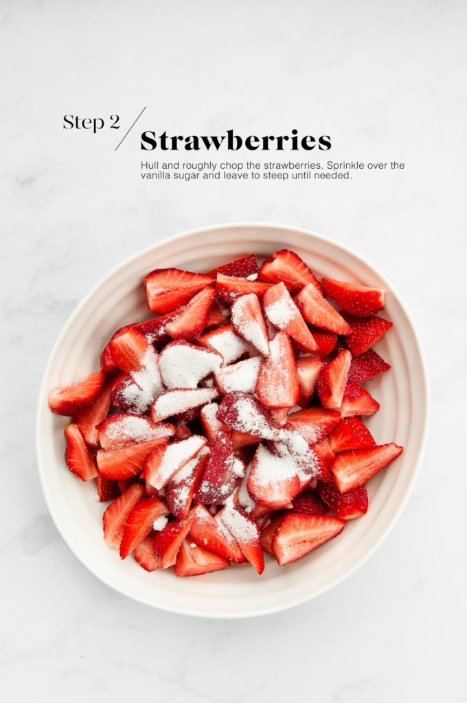 strawberries macerating in sugar in white bowl