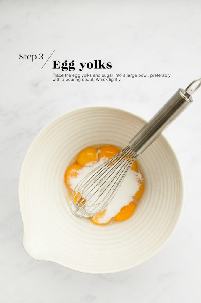 egg yolks with sugar in white mixing bowl