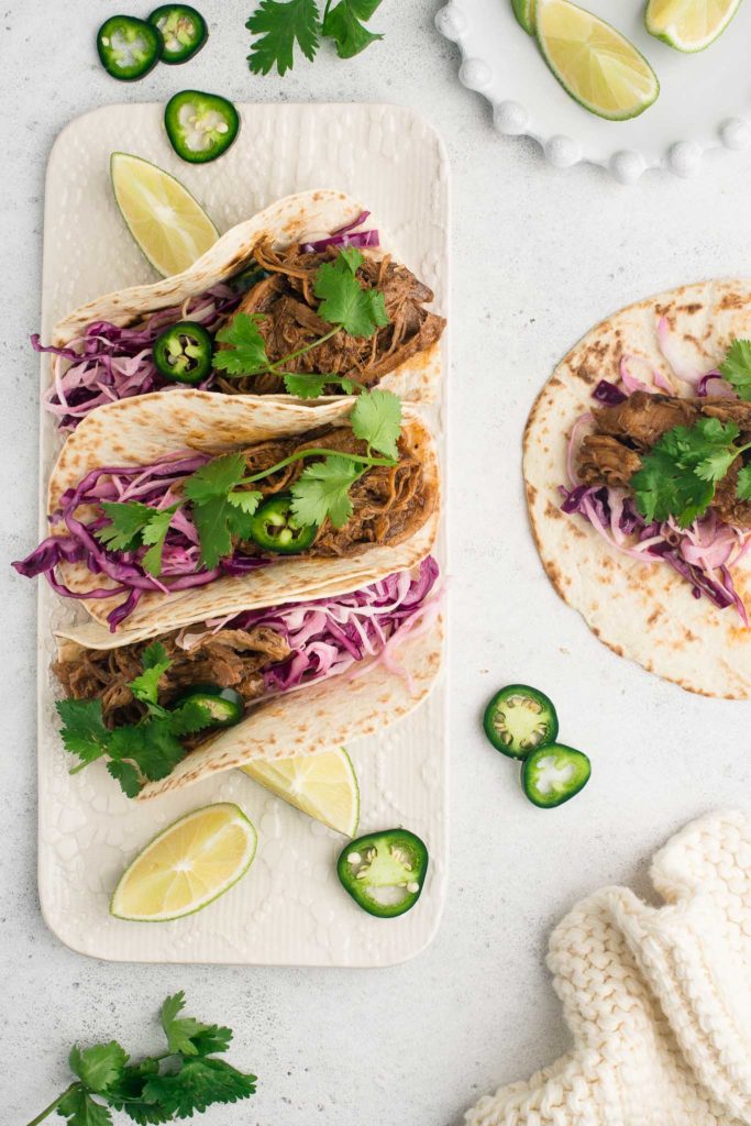 pulled pork tacos with creamy coleslaw on white plate
