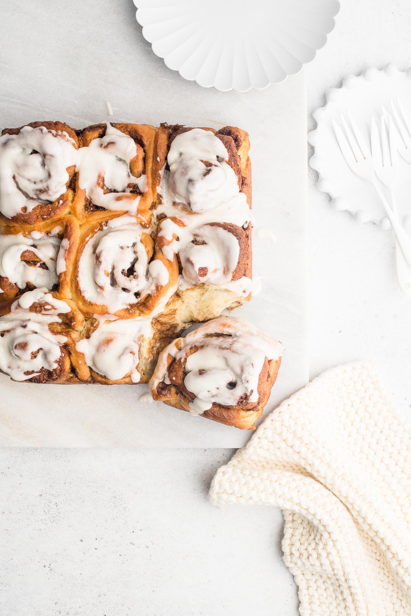 iced cinnamon rolls with white plates