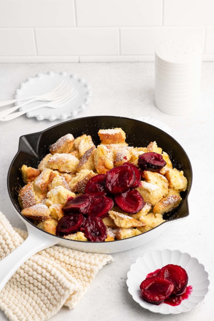 kaiserschmarrn with plums in white cast iron pan