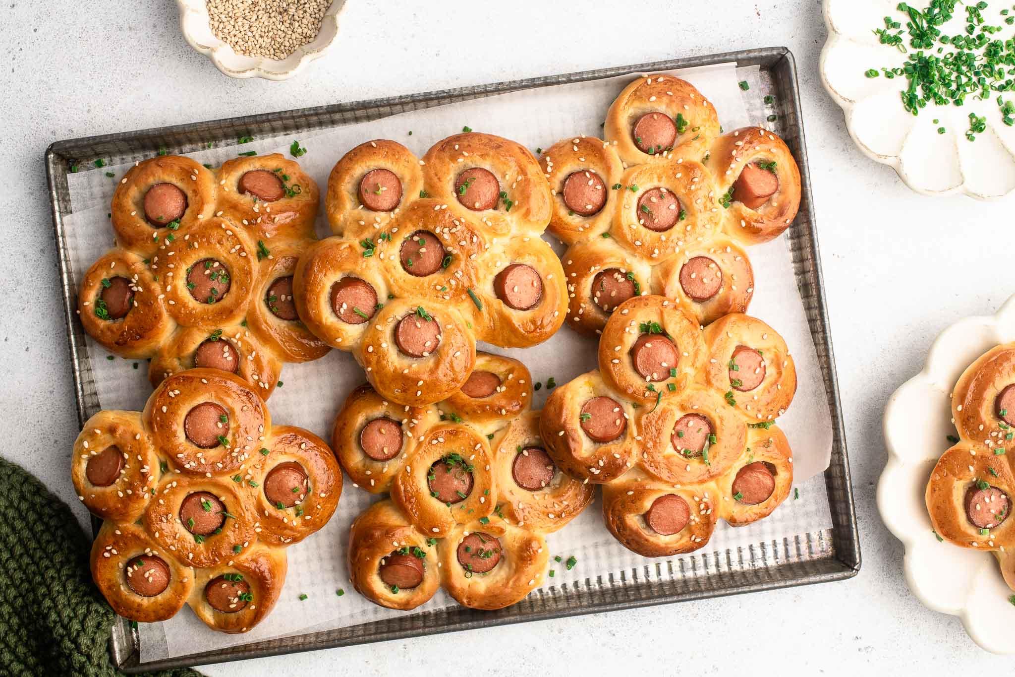 hot dog flower buns on lined baked tray with garnish