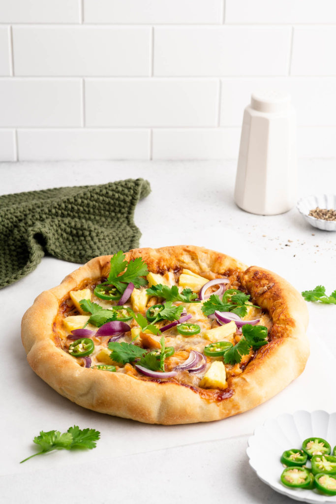 bbq chicken pizza with fresh herbs on table