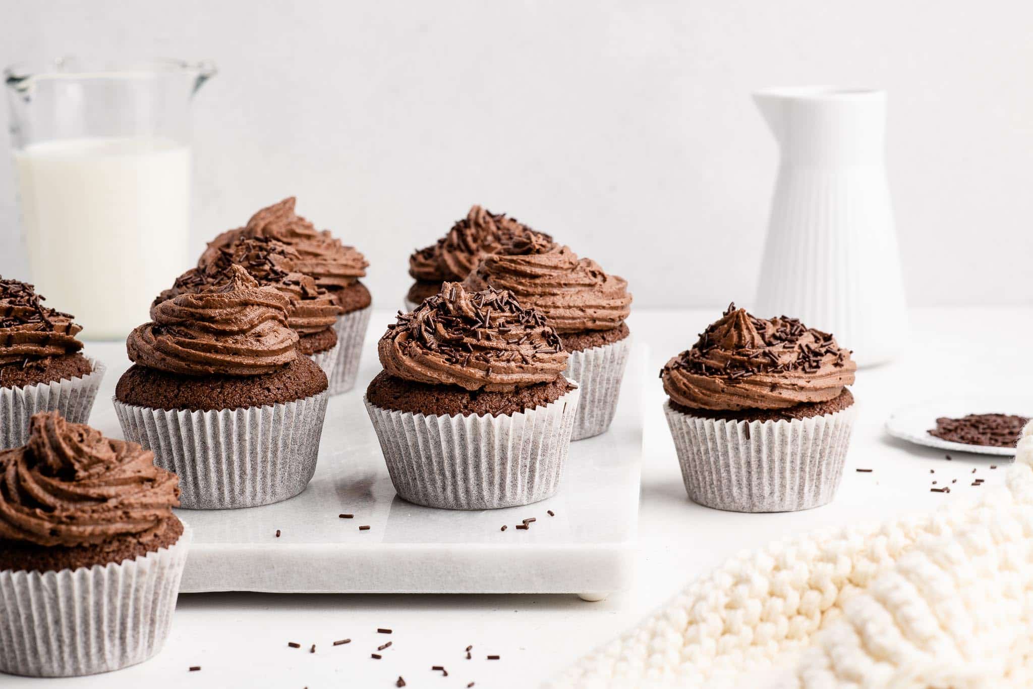 chocolate cupcakes with chocolate buttercream frosting on marble table