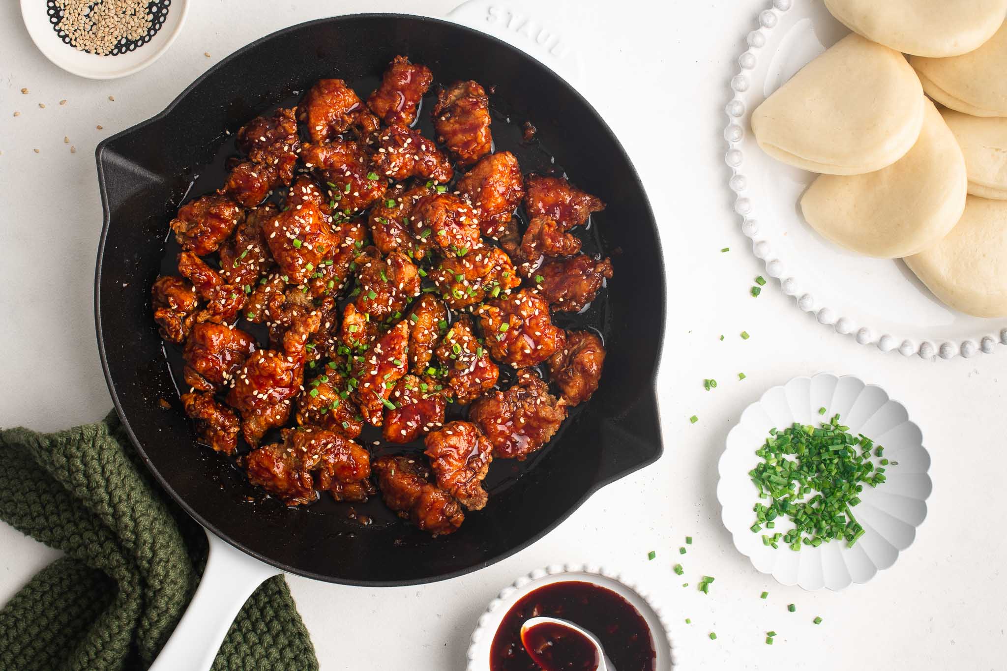 korean fried chicken in pan with steamed bao buns