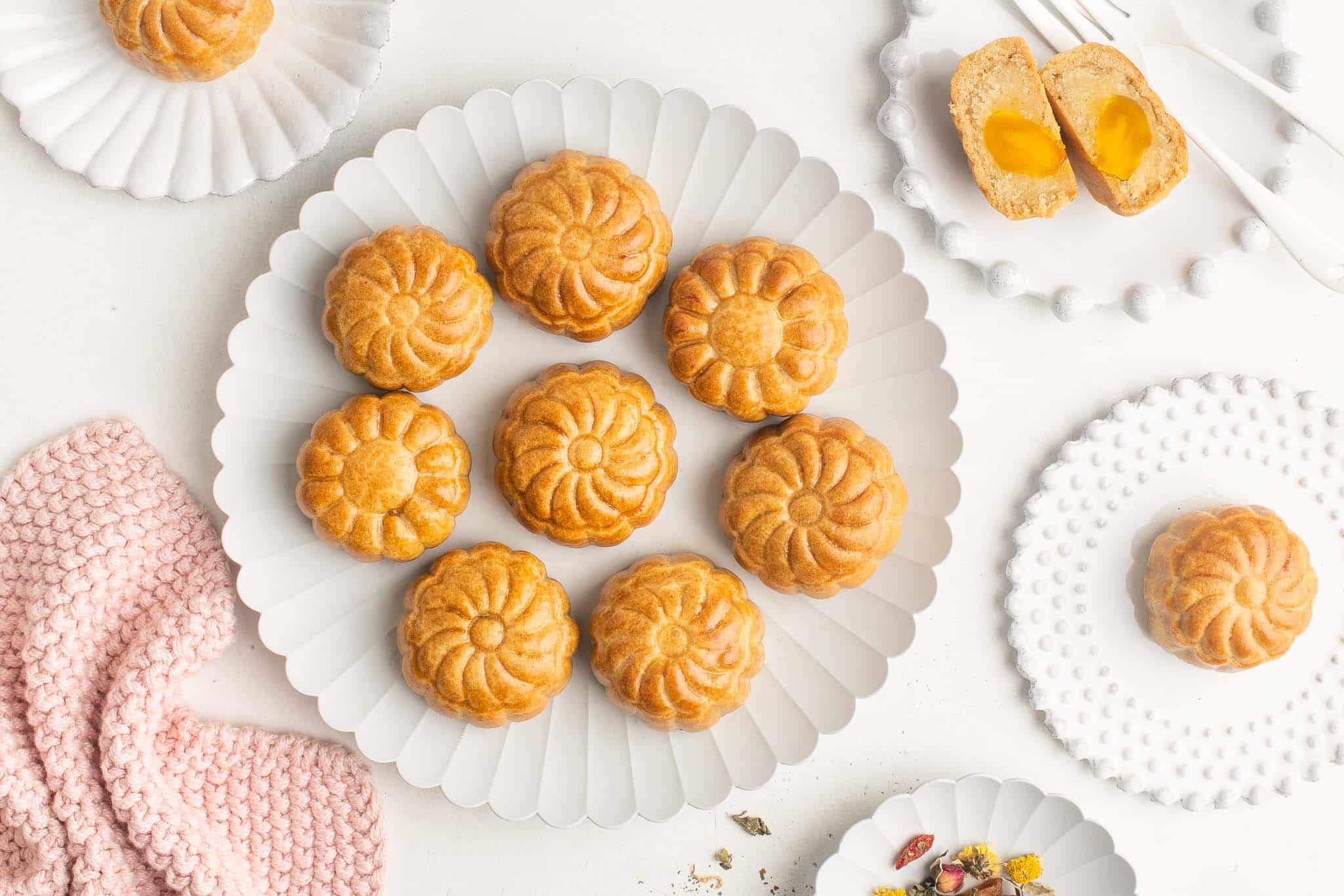 mooncakes with lotus seed paste and salted egg yolks on white plate