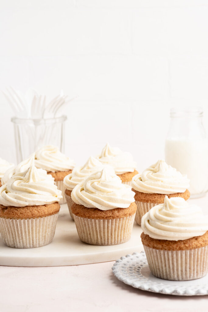 vanilla cupcakes with vanilla buttercream frosting with bottle of milk