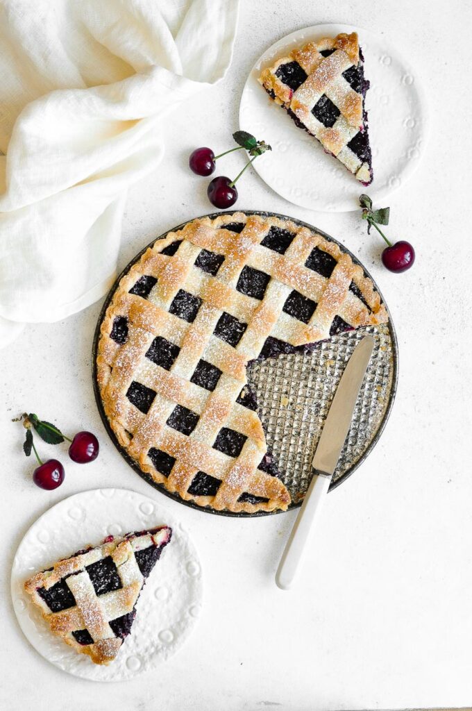 cherry pie with slices on white plates