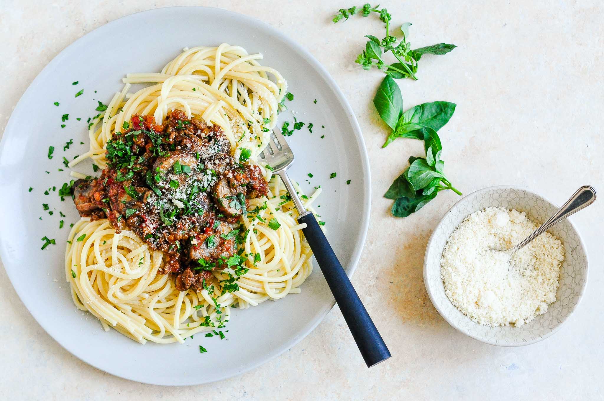 vietnamese spaghetti bolognese with cilantro on plate with cheese