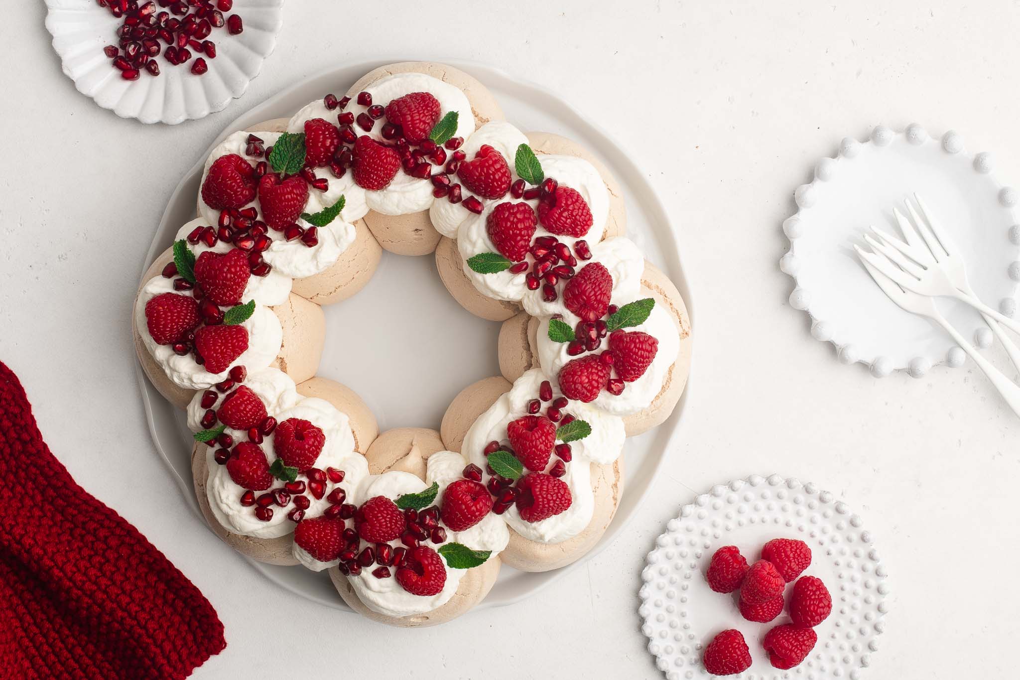 christmas pavlova wreath with raspberries and pomegranates