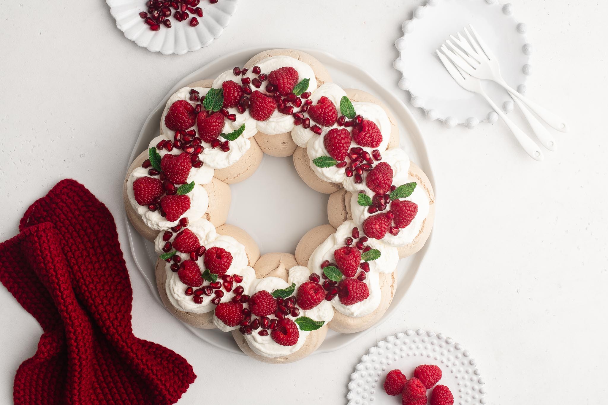 pavlova wreath with fresh berries on a white cake plate
