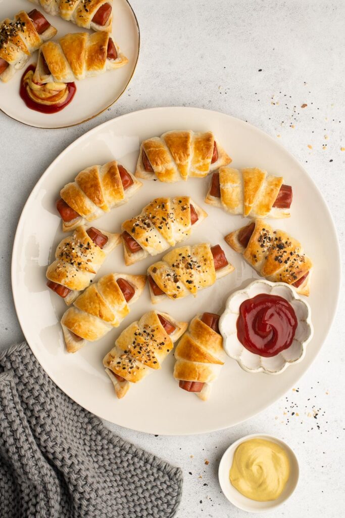 pigs in blankets on plate with ketchup and mustard