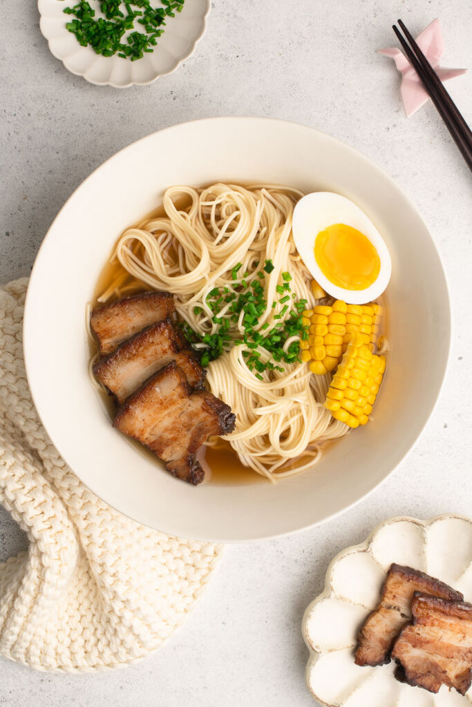 shoyu ramen with pork, egg and corns in cream bowl