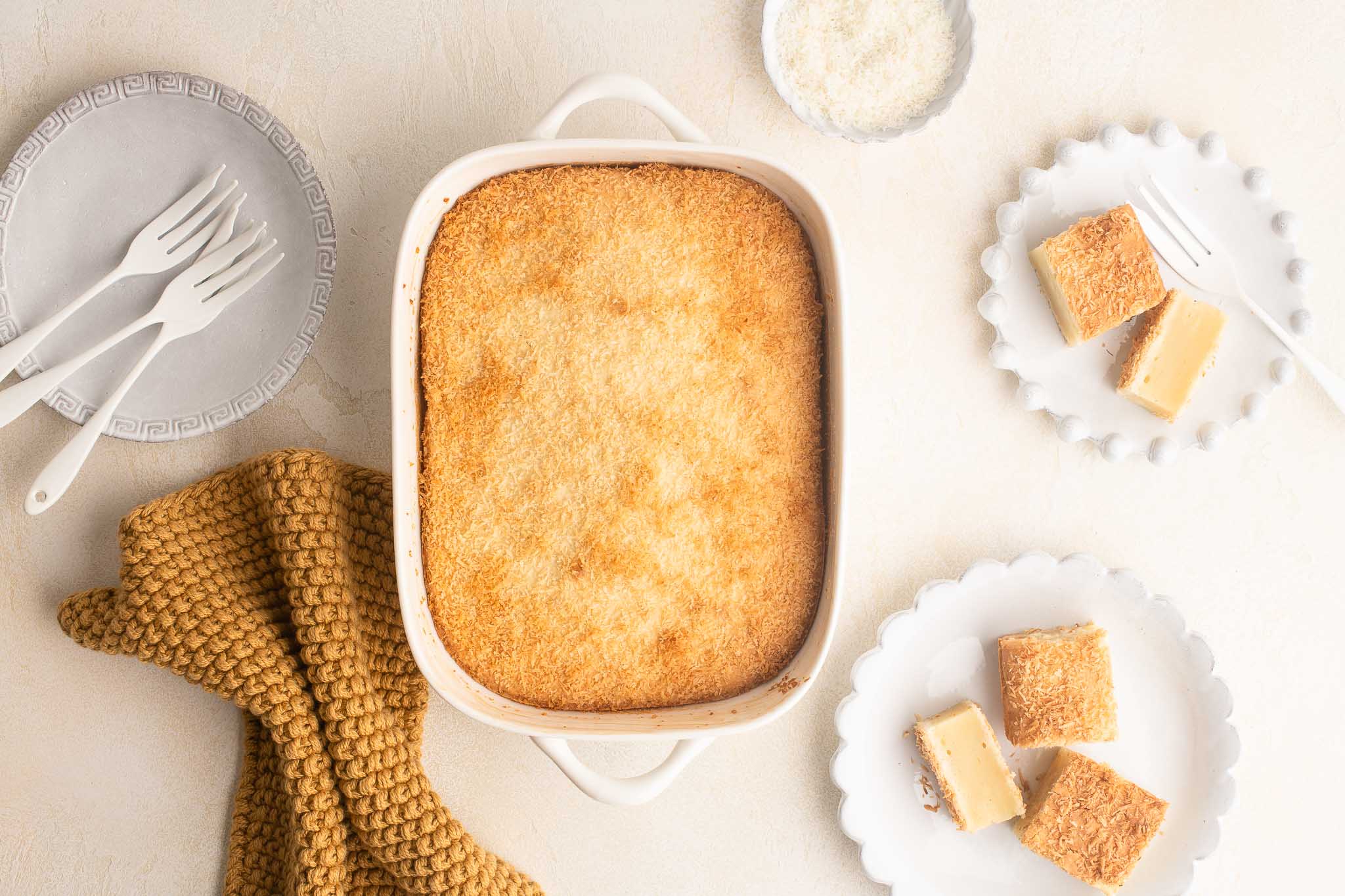 butter mochi cake in baking dish sprinkled with coconut