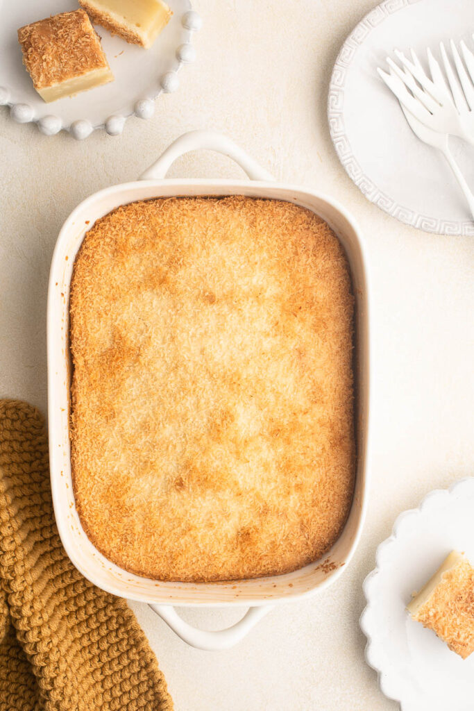 butter mochi cake in white baking dish with coconut