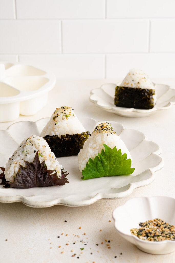 onigiri wrapped in shiso leaves on white plate