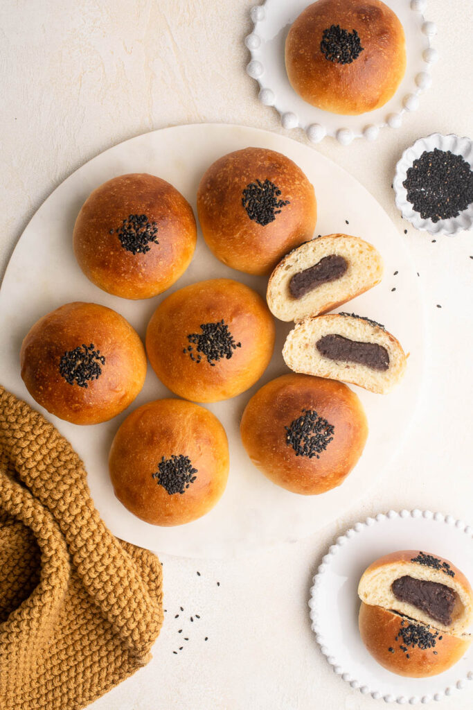 red bean buns (anpan) on tray with black sesame seeds