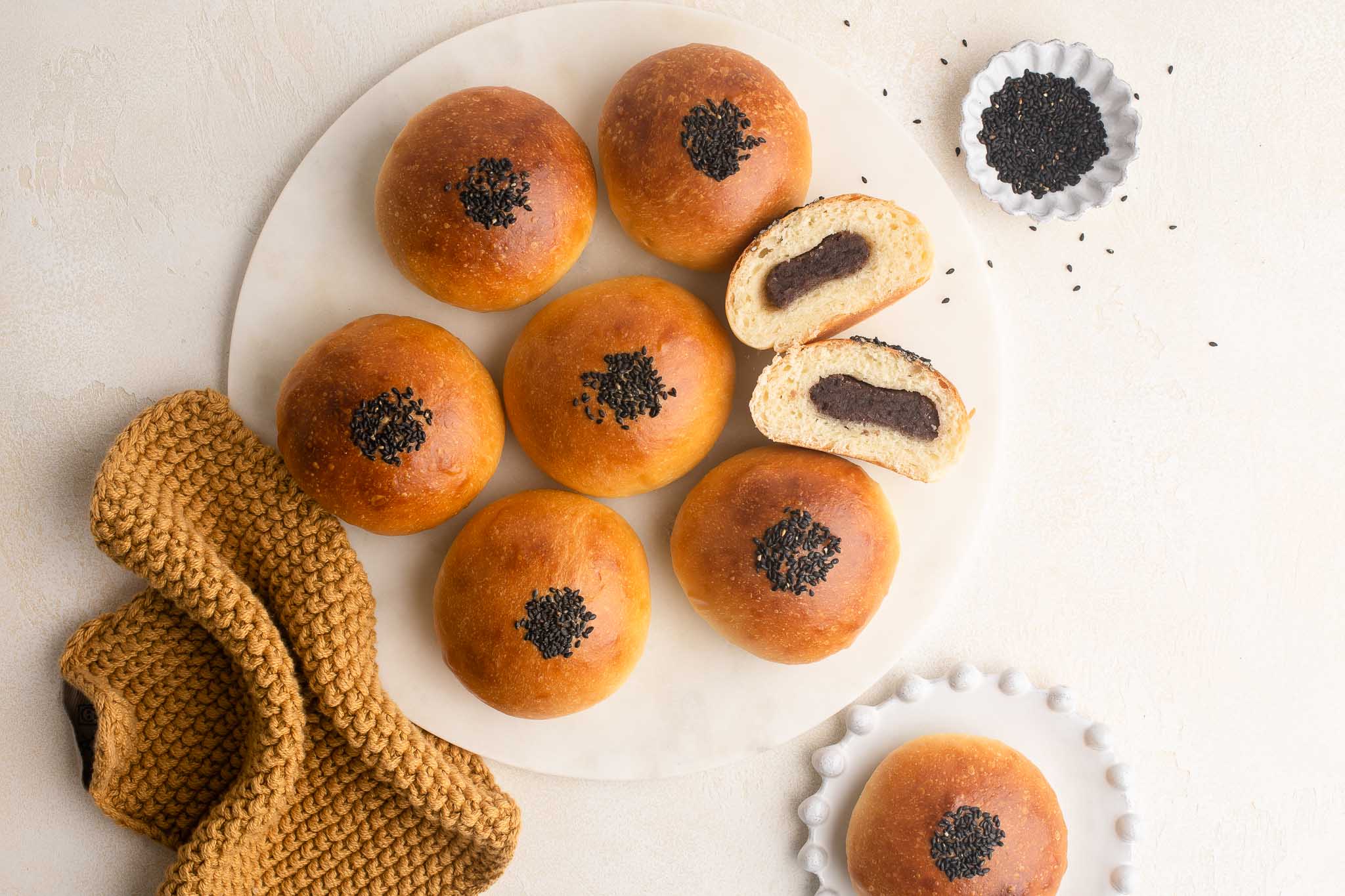 red bean buns (anpan) with black sesame seeds on tray with cloth