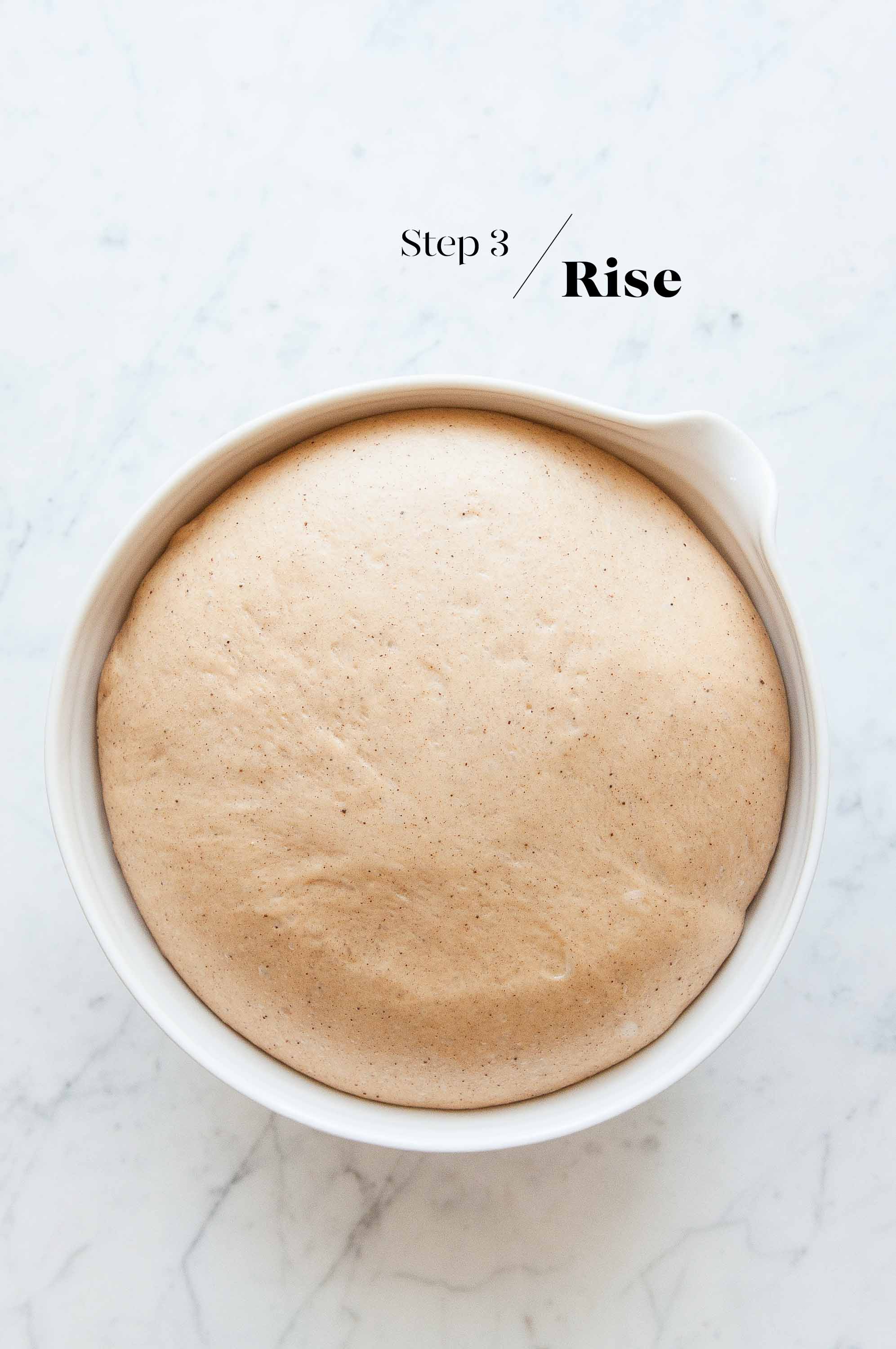 hot cross bun dough in white mixing bowl