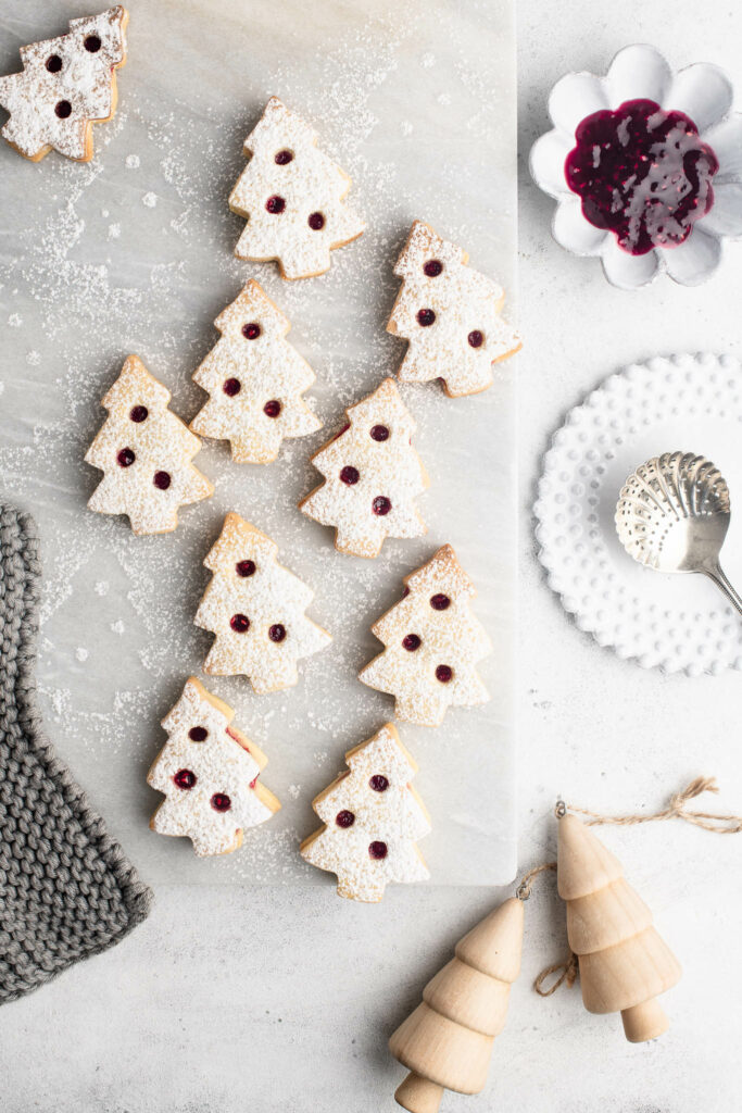 christmas tree linzer cookies on marble board