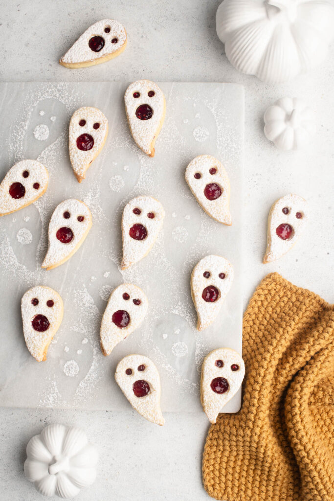 halloween ghost linzer cookies with raspberry jam on marble plate