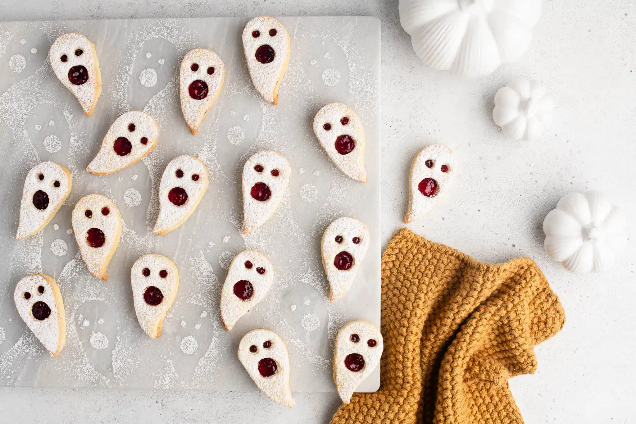 halloween linzer cookies dusted with icing sugar on marble plate