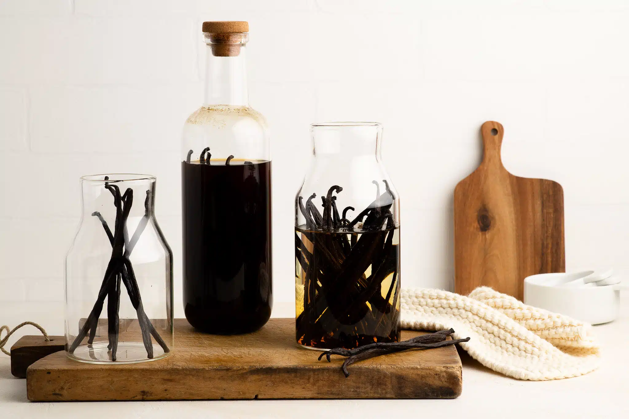 homemade vanilla extract in glass bottles with wooden board