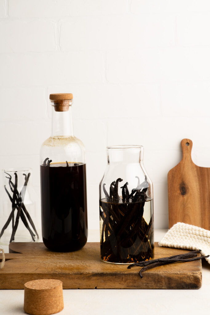homemade vanilla extract in glass bottle on wooden board