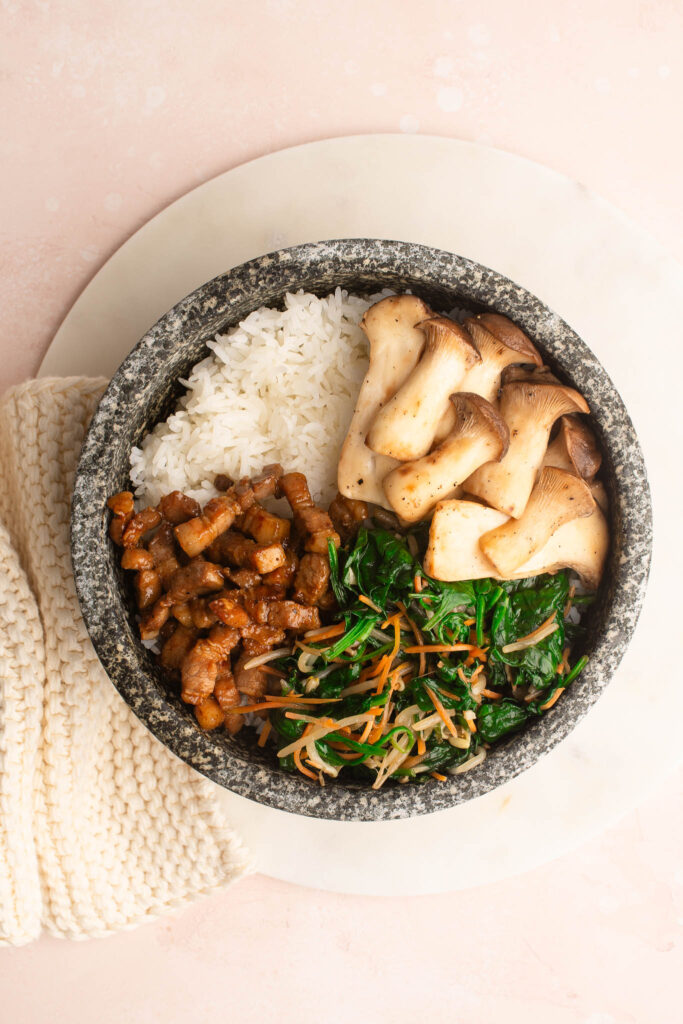 preparing bibimbap in stone bowl