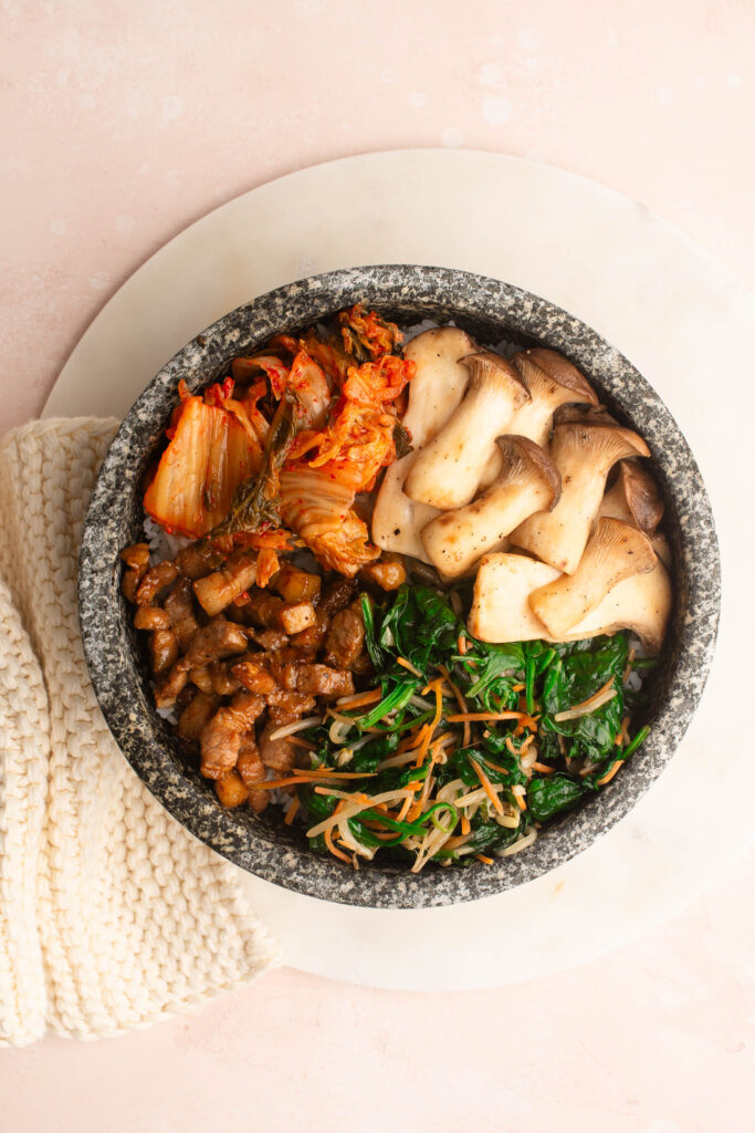 arranging bibimbap in bowl