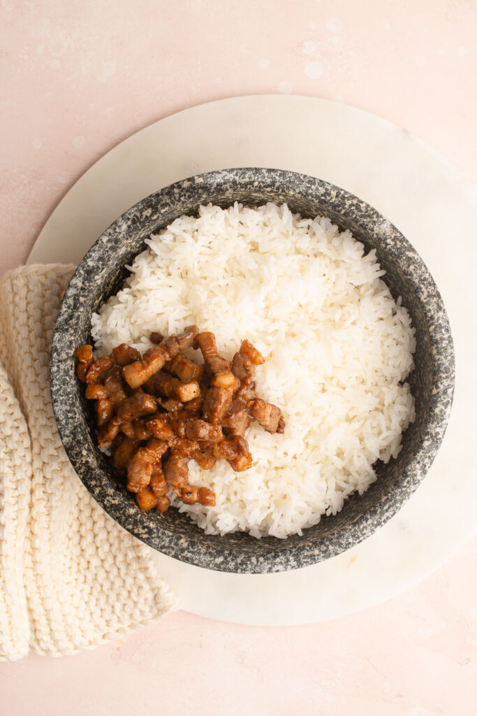 steamed rice with pork belly in stone bowl