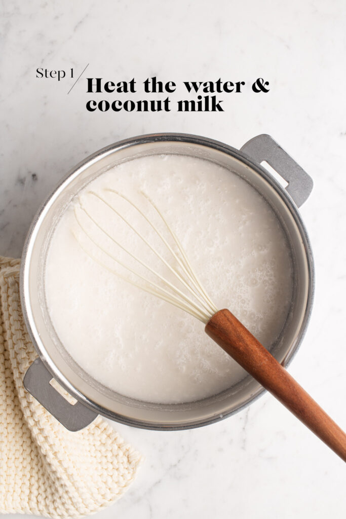 water and coconut milk in saucepan with whisk