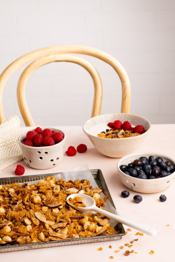 homemade granola on baking tray with fresh berries