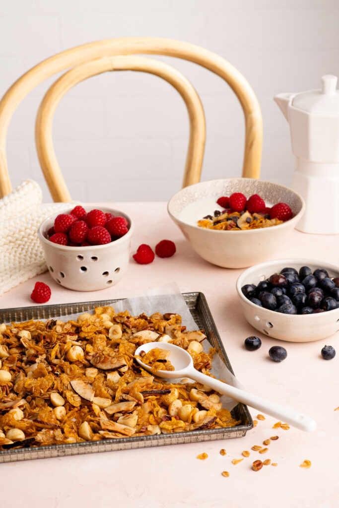 homemade granola on baking tray with white spoon
