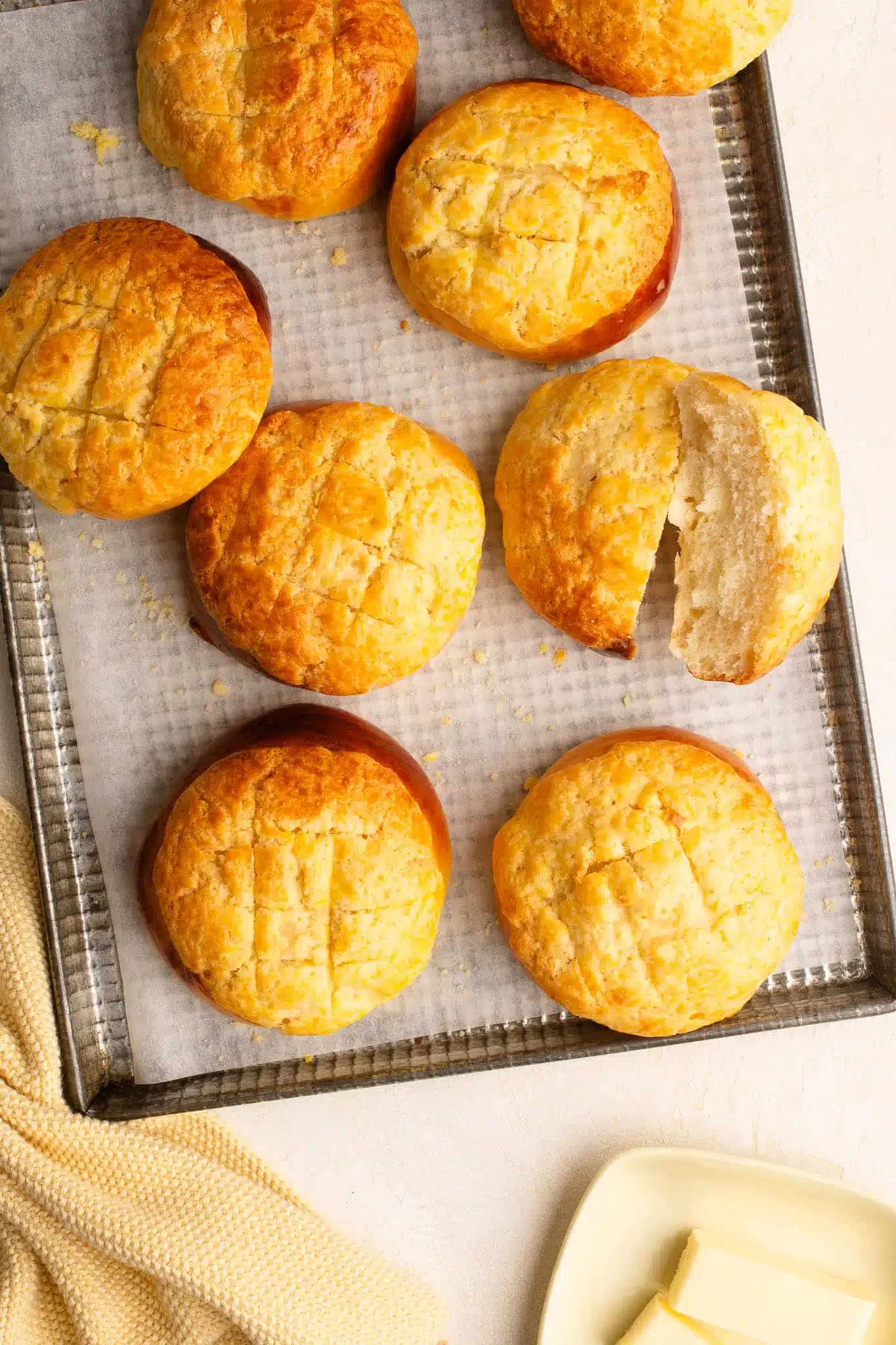 pineapple buns on baking tray with yellow cloth