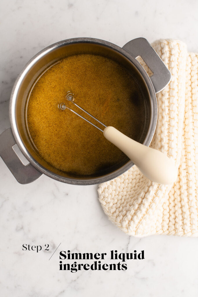 wet ingredients for granola in saucepan with whisk