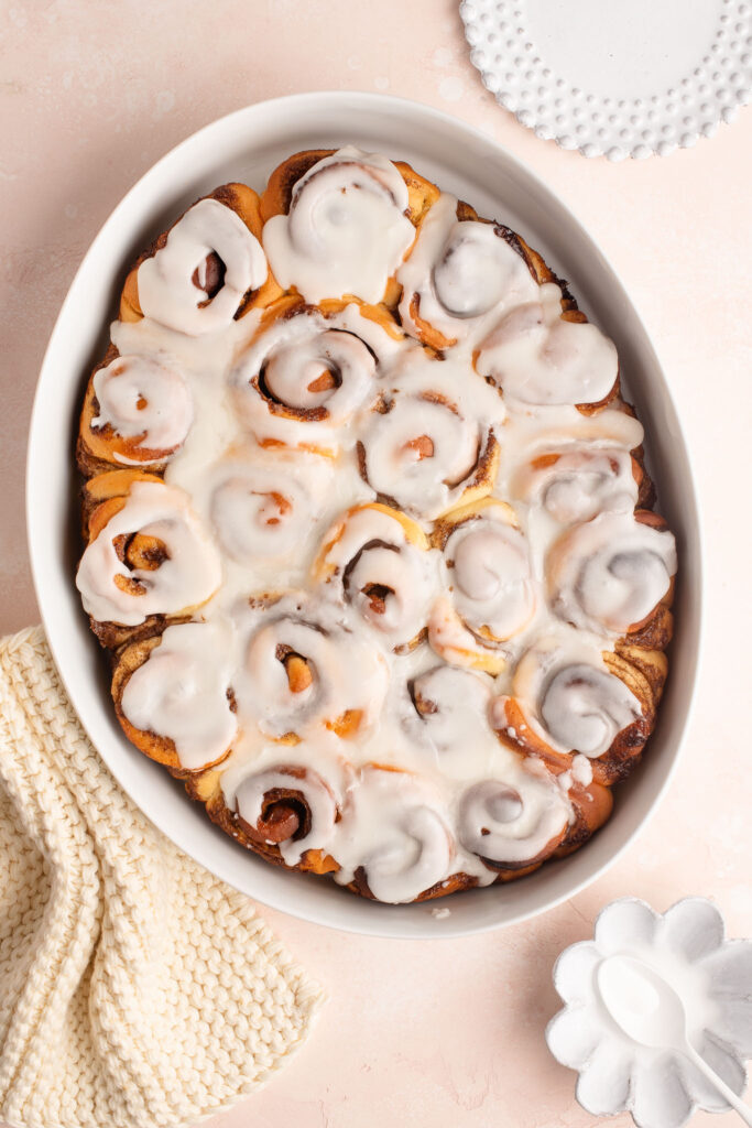 iced mini cinnamon rolls in white baking dish