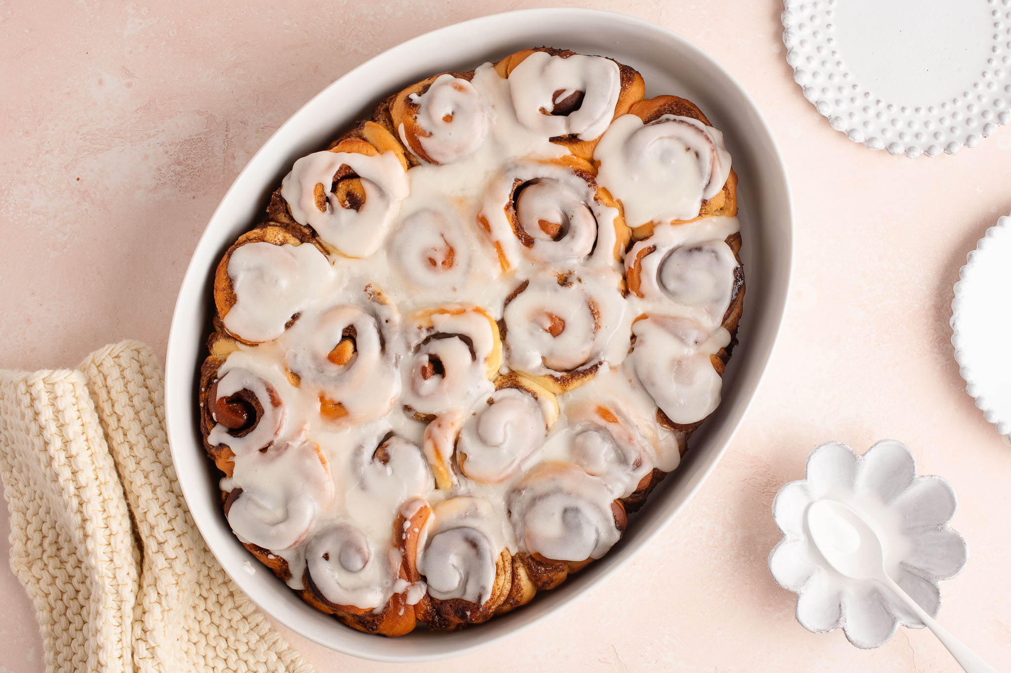 mini cinnamon rolls with frosting in white oven dish